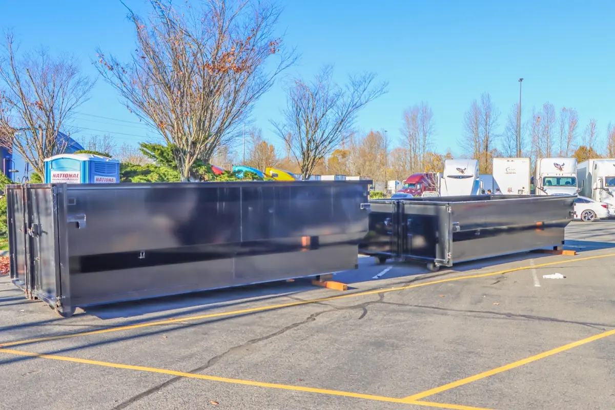 Professional dumpster rental service with roll-off container on residential driveway in Harrisville